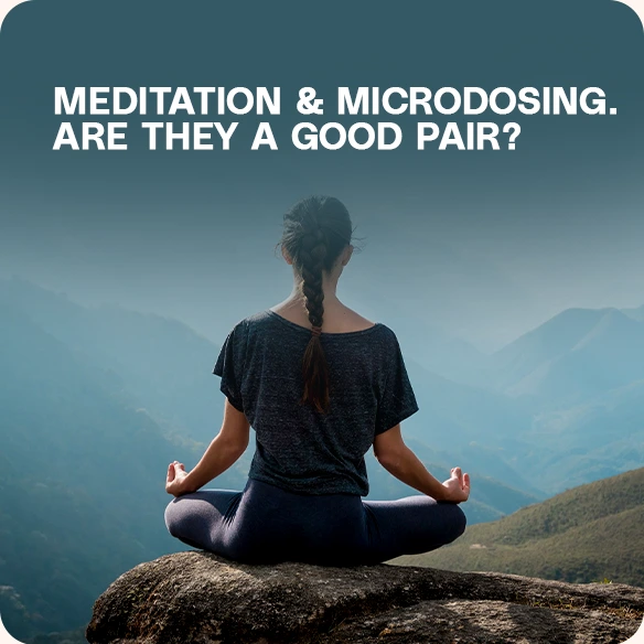 A woman sitting in a meditation pose on a mountain.