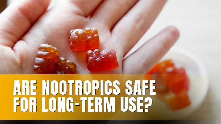 A hand holding small red gummy bears.