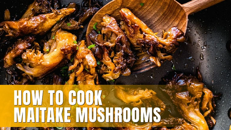 Maitake mushrooms in a pan with a wooden spoon